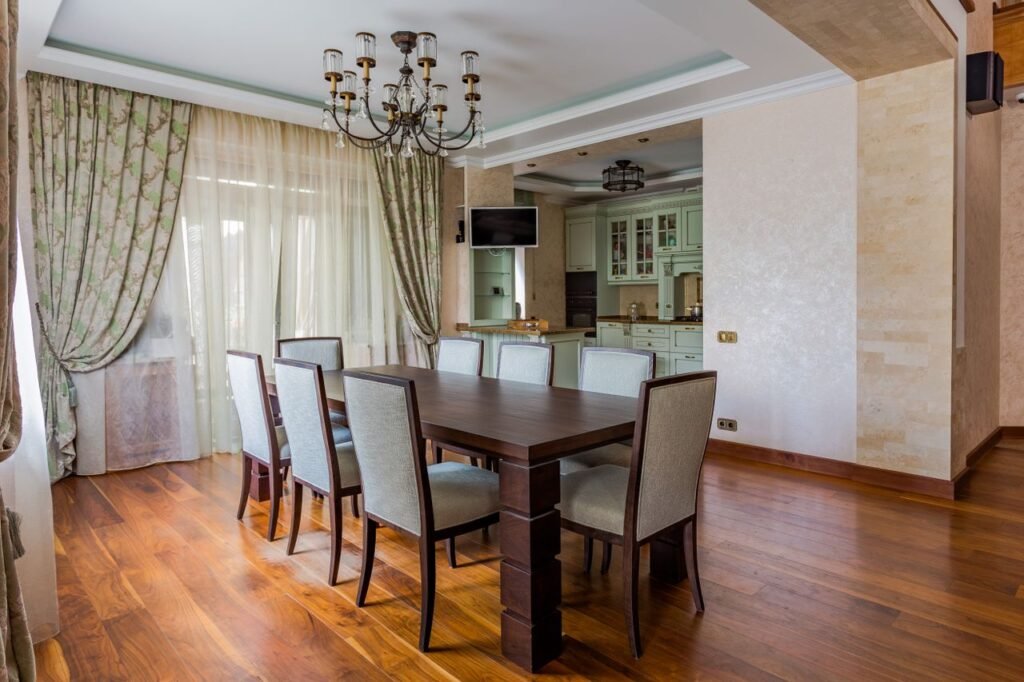 Spacious dining room with a dark wooden table, elegant chairs, and ambient lighting.