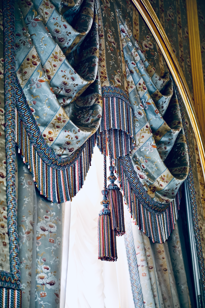 Luxurious floral curtains with intricate tassel details bring a traditional touch to any interior.