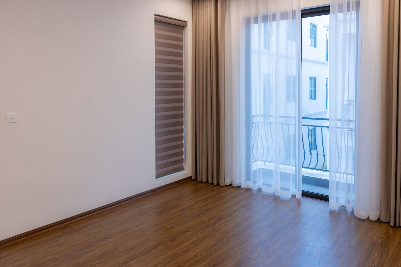 Bright modern room with wooden floor and large windows, ideal for real estate or interior design inspiration.